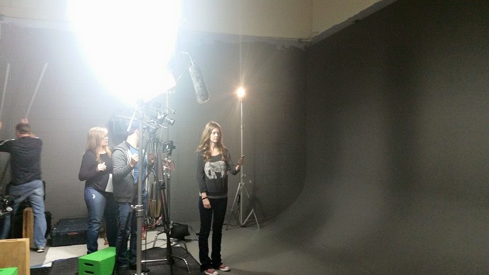 The image shows a student during the recording of the statistics series in a film studio